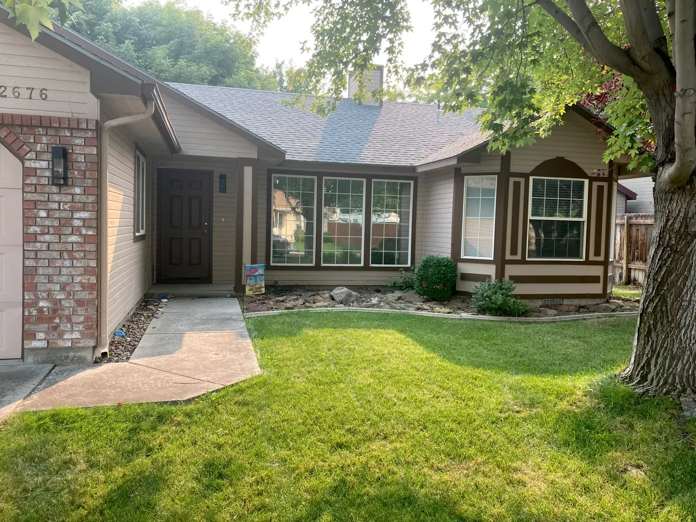 Before: tan siding and front entry before exterior house painting in Star, Idaho
