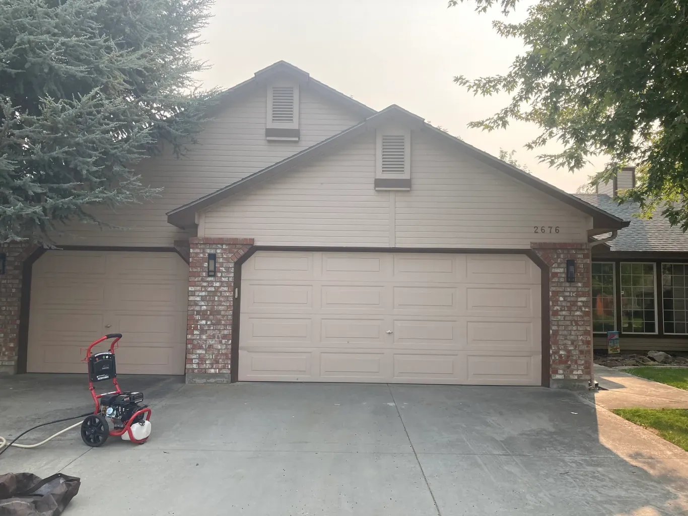 Before: tan house exterior and garage door before exterior painting in Star, Idaho