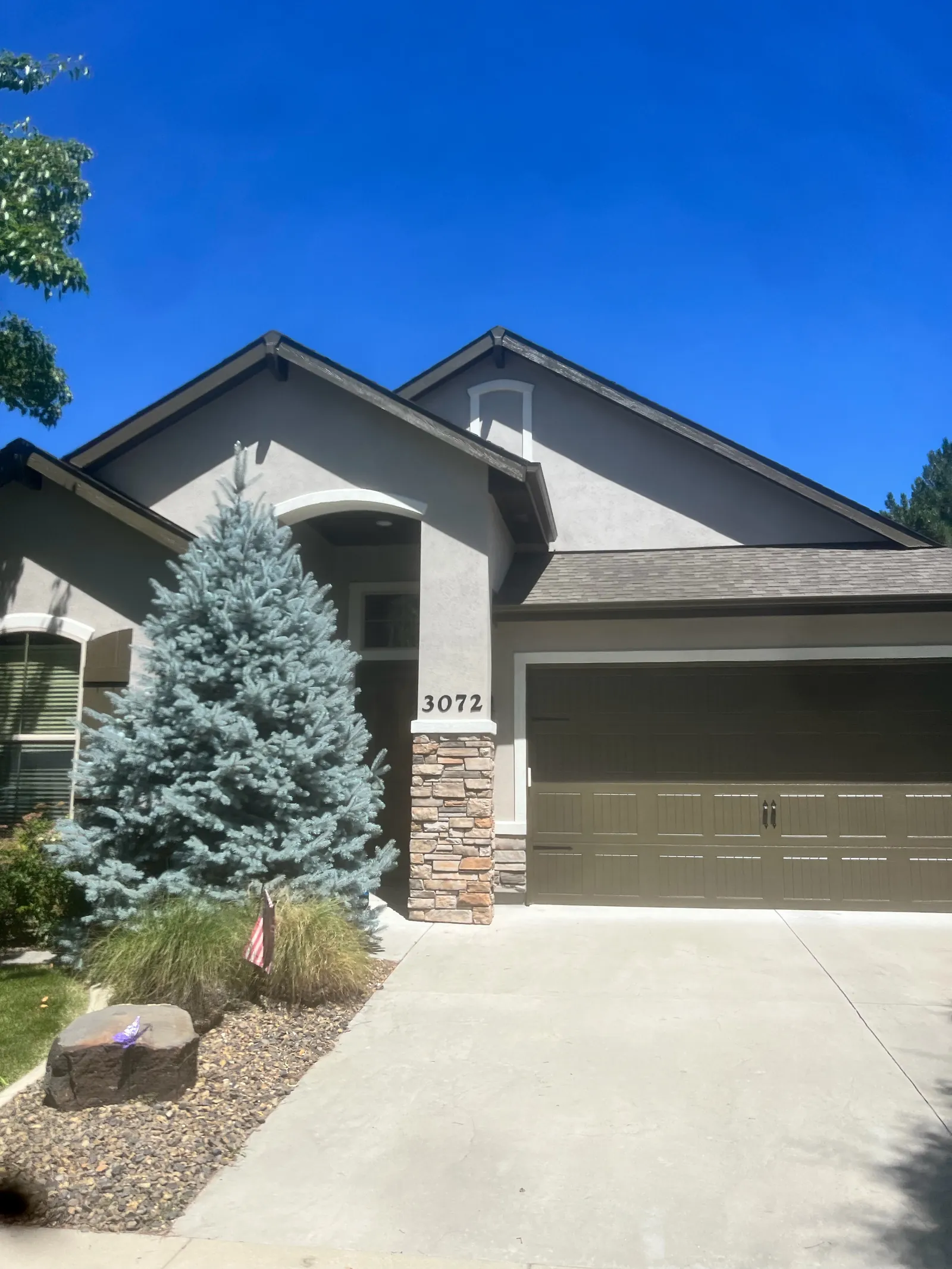 Gray home exterior with stone accents and garage after painting, Treasure Valley