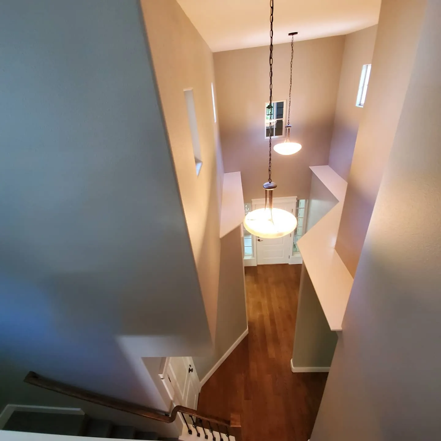 Freshly painted two-story stairwell and upstairs hallway with pendant light in a Star, Idaho home