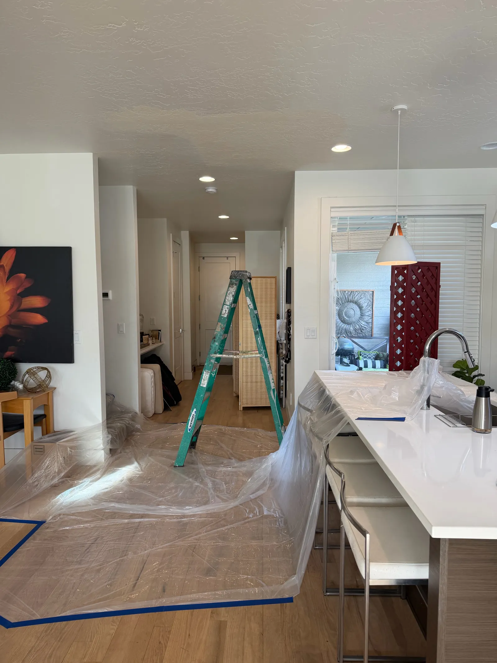 Open kitchen and living area with floors masked during interior painting, Treasure Valley
