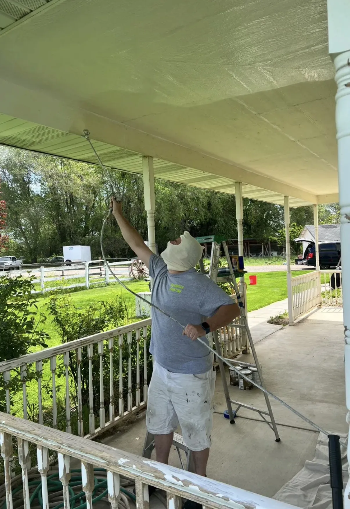 Glenn Painting Co. painter spray-painting a porch ceiling in Star, Idaho